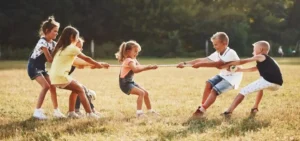 Attività Fisica Per I Bambini - Bambini E Bambine Giocano Al Tiro Alla Fune.